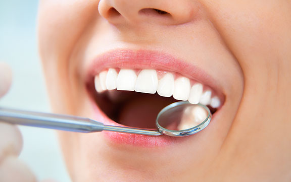 Up close image of a patient getting her shiny teeth examined.