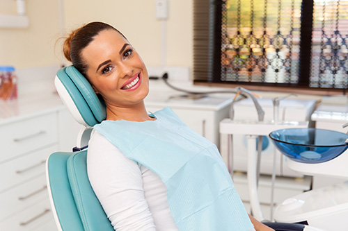Young woman sitting in the dental chair, smiling.