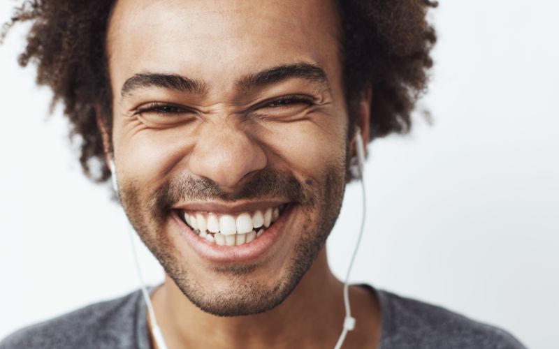man with earbuds in smiling