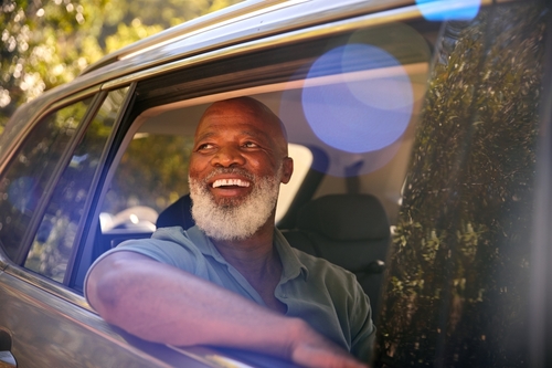 senior male smiling in the car